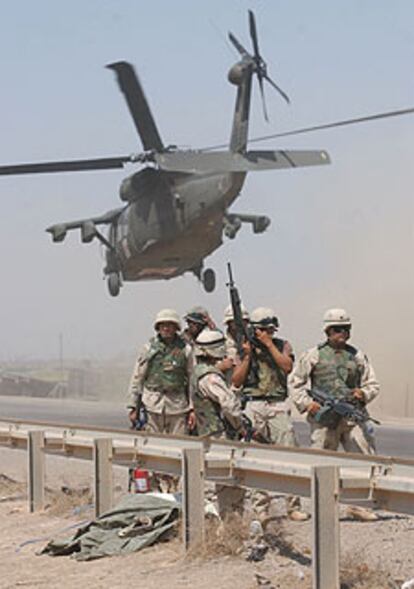 Un Black Hawk sobrevuela a soldados de EE UU en Bagdad.