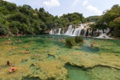 Bañistas frente a las cascadas del parque nacional de Krka, en Croacia.