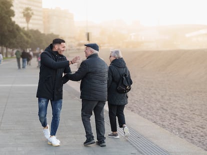 El futbolista saluda a una pareja en el paseo Marítimo de Riazor. 