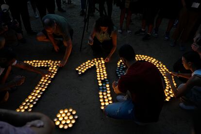 Varias personas encienden velas en el lugar del festival de Nova, en el aniversario del ataque de Hamás, este lunes. 