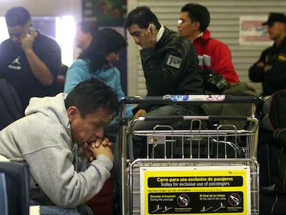 Varios pasajeros aguardan en la terminal 2 del aeropuerto de Madrid alguna información sobre sus vuelos cancelados.