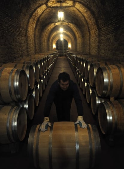 Un empleado coloca barricas de vino, en una bodega de Cenicero, en La Rioja.