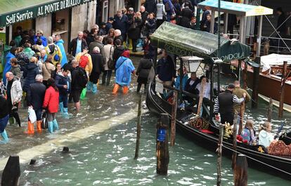 Turistas caminham pelas ruas alagadas de Veneza, na segunda-feira, 29 de outubro. Os meteorologistas preveem uma melhora nas condições climáticas. Nas últimas 48 horas, foram realizadas mais de 7.000 operações de resgate em toda a Itália.