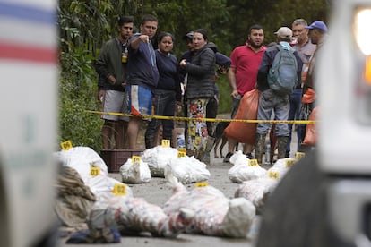 Residentes de El Naranjal miran algunos de los cuerpos recuperados por rescatistas tras la avalancha de este martes. 