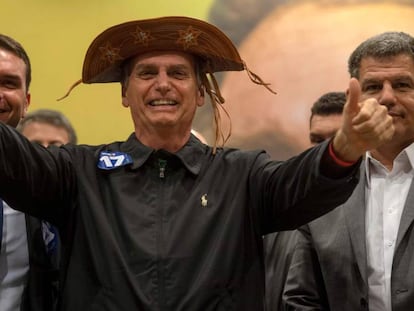 Jair Bolsonaro (c) en un acto junto a su hijo, el senadorFlavio Bolsonaro (i) y el presidente del PSL, Gustavo Bebianno, en Río de Janeiro.