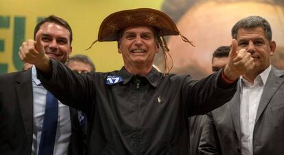 Jair Bolsonaro (c) en un acto junto a su hijo, el senadorFlavio Bolsonaro (i) y el presidente del PSL, Gustavo Bebianno, en Río de Janeiro.