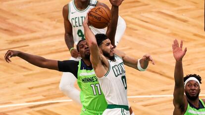 Jayson Tatum se dispone a anotar entre dos jugadores en el Celtics-Timberwolves.