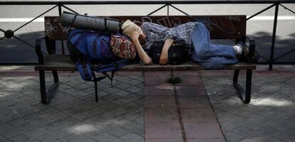 Una mujer duerme en un banco de Madrid.