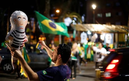 Un hombre sostiene un globo del expresidente Lula da Silva vestido como un reo en una manifestaci&oacute;n en Curitiba (Paran&aacute;)