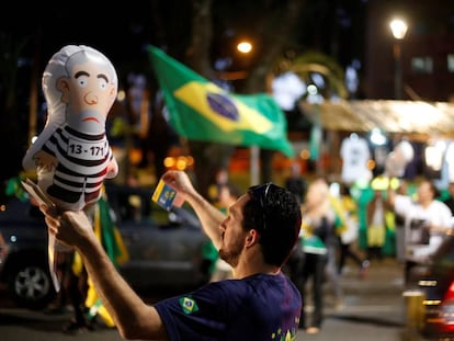 Un hombre sostiene un globo del expresidente Lula da Silva vestido como un reo en una manifestaci&oacute;n en Curitiba (Paran&aacute;)