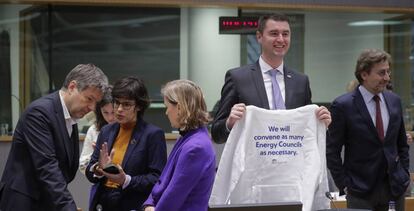 El ministro alemán de Asuntos Económicos, Robert Habeck, conversa con la ministra belga de Energía, Tinne Van der Straeten. A la derecha, el ministro de Economía de Croacia, Davor Filipovic, sostiene una camiseta con la consigna