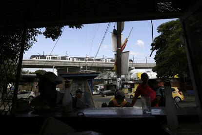 Vecinos del barrio de San Miguelito, en una terraza bajo el viaducto que emplea el metro para cruzar la ciudad.