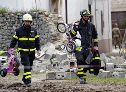 Dos bomberos trabajan en las labores de desescombro en la localidad de Onna