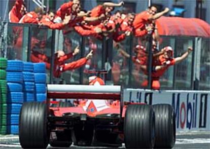 Miembros del equipo de Ferrari felicitan a Michael Schumacher tras su triunfo.