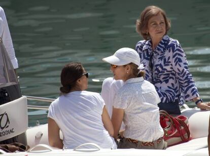 Doña Sofía, acompañada de su hija Elena (con gorra), sigue en lancha las prácticas de sus nietos en el curso de vela en Mallorca.