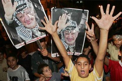 Niños palestinos muestran fotografías de Arafat durante un acto celebrado anoche en la ciudad de Gaza.