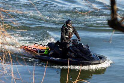 Un policía de estatal navega por las orillas del río Potomac buscando restos de las aeronaves colisionadas.