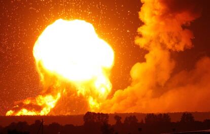 Llamaradas se elevan en el cielo durante una explosión en un depósito de municiones durante un incendio en la localidad de Kalynivka (Ucrania).