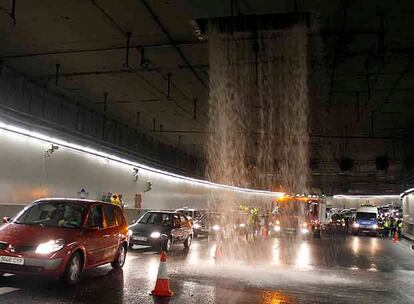 Los coches pasan junto a la cascada de agua en el túnel de la M-30.