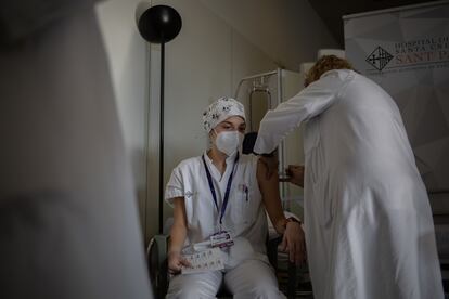 Una enfermera vacuna a un profesional sanitario con la vacuna de Pfizer-BioNtech contra la covid-19 en el hospital de la Santa Creu i Sant Pau de Barcelona.