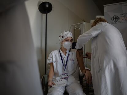 Una enfermera vacuna a un profesional sanitario con la vacuna de Pfizer-BioNtech contra la covid-19 en el hospital de la Santa Creu i Sant Pau de Barcelona.