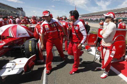 Alonso observa su coche durante el Gran Premio de Gran Bretaña.
