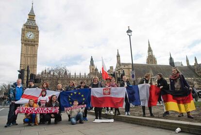 Un grupo de manifestantes posan para una fotografía con banderas de Inglaterra, de la Unión Europea, de Polonia, de Francia y de Alemania en frente de la Torre Elizabeth, más conocida como el 'Big Ben', cerca del Parlamento durante la manifestación en la plaza del Parlamento, en Londres, como parte de una jornada nacional de apoyo a los migrantes en el Reino Unido.