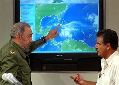 El presidente cubano, Fidel Castro, habla sobre el huracán Iván con el jefe de meteorología de la televisión cubana durante un programa en directo.