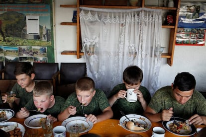 Un grupo de adolescentes del club ‘Patriota’ en Crimea visitó el campamento de campo de la escuela, llamado 'Caballeros rusos', durante el verano. En la foto, los niños del club patriótico militar 'Patriota' de la ciudad de Evpatoria en Crimea, que están de visita en la base del club patriótico militar 'Caballeros rusos', comen en el pueblo de Sengileyevskoye, en la región de Stavropol, Rusia.