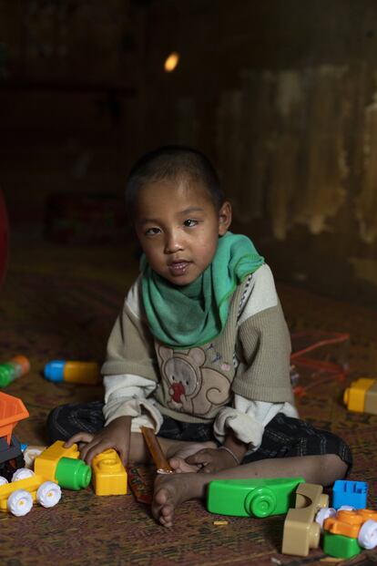 Todas las mañanas Kum juega sobre la alfombra de la cabaña donde vive con su familia, en la aldea de Phonxay, Laos.
