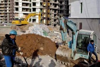 Varios obreros chinos trabajan en una obra en la ciudad de Qingdao, en la provincia oriental china de Shandong. EFE/Archivo