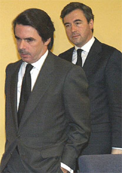 El presidente Aznar, acompañado del ministro Acebes antes de la lectura de la declaración institucional.