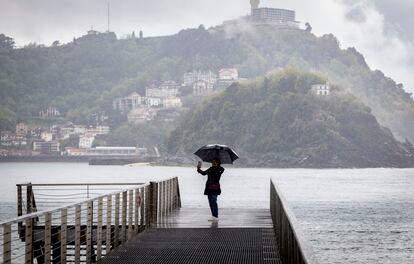 Una mujer se fotografía este martes con su paraguas en la pasarela del Náutico de San Sebastián.