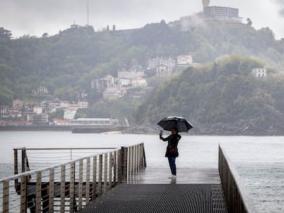 Una mujer se fotografía este martes con su paraguas en la pasarela del Náutico de San Sebastián.