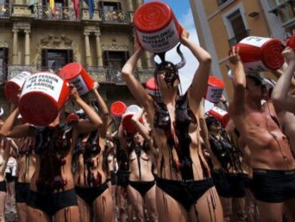 Un centenar de activistas se desnudan y se tiñen de rojo ante el Ayuntamiento de Pamplona en protesta por las corridas de toros