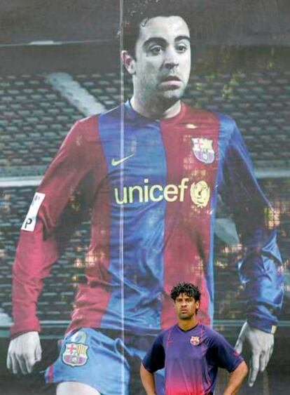 Rijkaard, en el entrenamiento ante un cartel con la foto de Xavi.