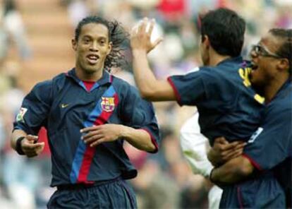 La estrella brasileña del Barça celebra su gol con Saviola y Davids.