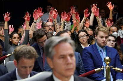 A group of activists protesting on Tuesday against Israel's airstrikes in Gaza behind Secretary of State Antony Blinken, at the Senate.