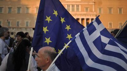 Un manifestante ondea una bandera de la Unión Europea y de Grecia