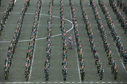 Un instructor militar camina entre los alumnos de primer año durante una clase de educación militar en el campus universitario de Harbin (China).