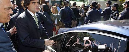 El consejero se monta en su coche oficial, donde un manifestante ha escrito la palabra "ladrón".