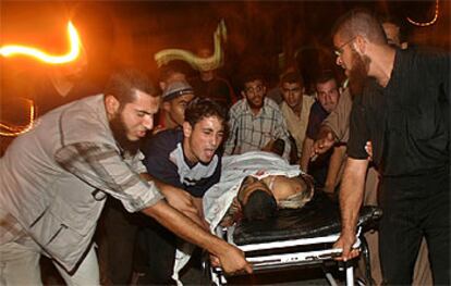 Varios palestinos transportan el cuerpo de uno de los dos miembros de Hamás asesinados por un misil israelí en Gaza.