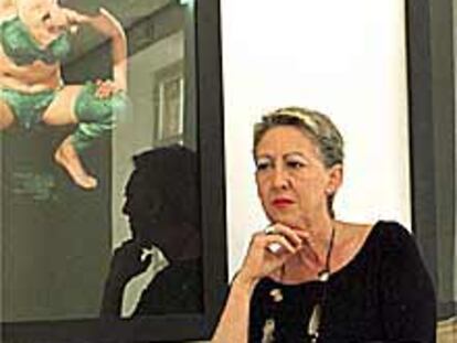 Carmen de la Calle, posa en su galería ante obras Mira Bernabeu.