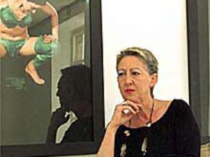 Carmen de la Calle, posa en su galería ante obras Mira Bernabeu.