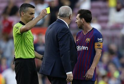 El arbitro Eduardo Berizzo (izquierda) muestra tarjeta amarilla a Lionel Messi.