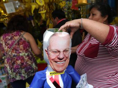 Una mujer sujeta una piñata del presidente peruano, Pedro Pablo Kuczynski.