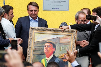 Bolsonaro recebe uma pintura durante visita à Ceagesp, em São Paulo, nesta terça-feira.