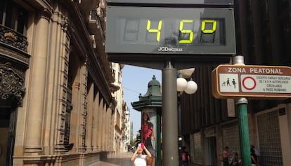 Una mujer fotograf&iacute;a un term&oacute;metro en el centro de Valencia