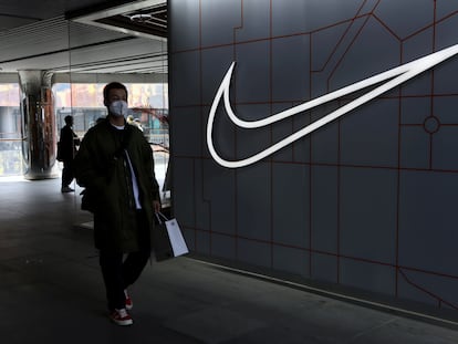 Un hombre camina junto a una tienda de Nike.