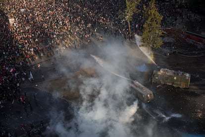 Manifestantes são atingidos por um canhão de água da polícia durante um protesto contra o Governo em Santiago, Chile, na sexta-feira 1 de novembro de 2019. 